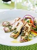Grilled halloumi cheese served with pesto and salad
