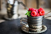Fresh raspberries in a stack of silver cups