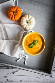 Cream of pumpkin soup with basil leaves