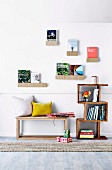 Decorative wall shelves with books on wooden bench and bookcase