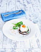 A stack of poached egg and salmon on a mushroom with watercress