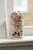 Blueberry cobbler ice cream in preserving jar on a windowsill