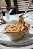 French onion soup being eaten in a restaurant
