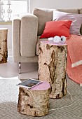 A stump of birch wood as a side table with the tops painted pink