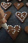 Gingerbread biscuits being decorated with icing