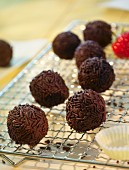 Rum truffles with chocolate sprinkles on a wire rack