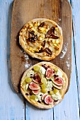 Two mini fruity pizzas on a wooden board