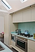 Fitted appliances in modern kitchen counter with sliding door