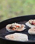 Mini vegetable pizzas on a barbecue