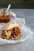 A pulled pork sandwich with coleslaw and barbecue sauce