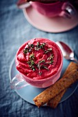 A cup of raspberry ice cream with thyme