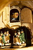 Detail of cuckoo clock with bird and dancing figurines in traditional costumes