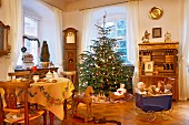 Christmas tree traditionally decorated and old-fashioned toys in interior with antique furnishings