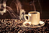 Heißer Kaffee in Tasse auf Kaffeebohnen