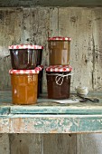 Jars of jam stacked in a rustic wooden cupboard