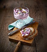 Herring salad in a glass bowl and on a slice of bread