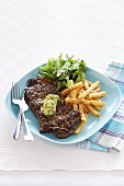 Peppered steak with herb butter, chips and salad