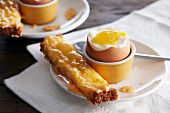 A soft boiled egg with a cheesy soldier