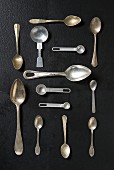 An arrangement of various spoons on a black surface