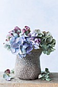 Posy of dried hydrangea flowers in small crocheted basket