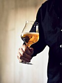 Mann hält Glas mit Bier (Sorte: India Pale Ale)