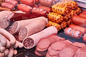 Various sausages and sliced meat on display