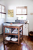Ländliche Küche mit Dielenboden, Spültisch und Küchenarbeitsplatte auf Holztisch mit Stauraum