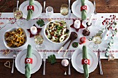 Various dishes on a table laid for Christmas dinner