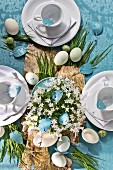 Easter table set with birch bark and blades of grass on blue wallpaper