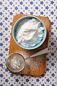 Icing sugar in a bowl and in a sieve