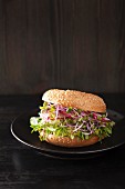 A bagel with cucumber, avocado, radish sprouts and radishes