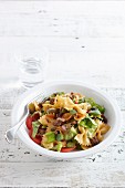 Pasta salad with vegetables and fried sausage