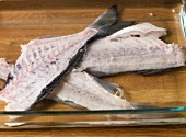 Fish carcasses in a glass dish for making fish stock