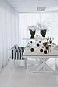 Modern table set for Christmas meal with artificial snow, moss balls and stag candelabra