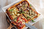 A square pizza with four different toppings