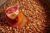 Dried pinto beans with a ham hock in a pot