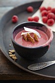 A smoothie bowl with raspberries, mango and coconut