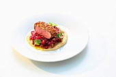 Duck breast with a sesame seed crust on a red cabbage salad, chickpea purée and orange sauce