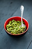 Wild garlic pesto in a red bowl on a wooden surface