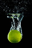 A lime falling into water with a splash