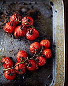 Roasted cherry tomatoes on a baking tray (seen from above)