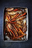 Roasted carrots and shallots on a baking tray