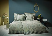 Scatter cushions with flanged edges on bed in blue and green bedroom
