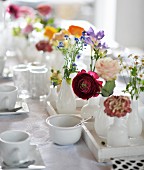Table set with white crockery and spring flowers