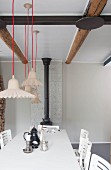 Various pendant lamps suspended from red cords above table