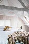 Romantisches Schlafzimmer unter dem Dach mit Bretterwand