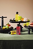 An arrangement of perfume bottles, fruit, flowers and vegetables