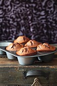 Flourless honey-orange chocolate muffins in a muffin tray
