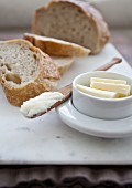 Sliced bread with butter and a wooden butter knife