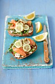 Wholemeal rolls topped with smoked salmon, cream cheese, cucumber and capers